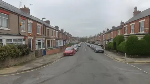 A typical street with terraced houses and cars parked outside