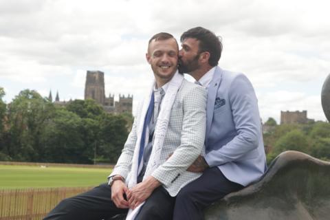 Newlyweds John, 39, and Les, 50, both in suits, sat atop Durham's riverside bull sculpture.