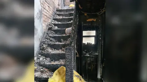Leicestershire Fire and Rescue Service Stairs in a house badly damaged by flames - and covered in rubble