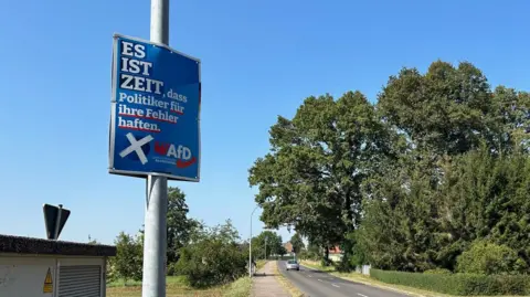 An AfD run  motion   is seen by a roadworthy  - it says "It is clip  that politicians reply  for their mistakes"