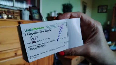 Abbi Hoxleigh Abbi holding her box of aripiprazole 