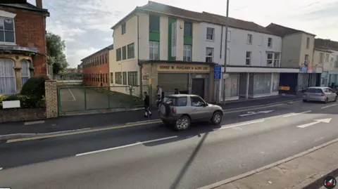 Google A gateway next to some empty buildings on a main road