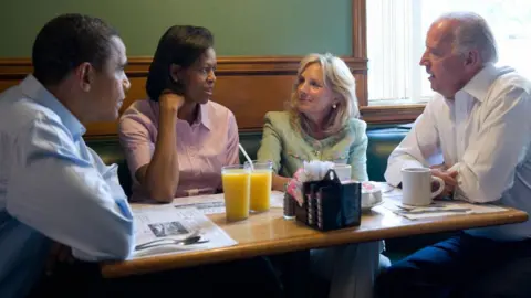 Getty Images 巴拉克·奥巴马（左）和他的妻子米歇尔·奥巴马（左二）与他的竞选搭档、美国副总统候选人参议员乔·拜登（右）和他的妻子吉尔·拜登共进早餐