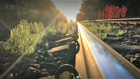 Network Rail Stock image of a railway track with workers wearing hi-vis jackets