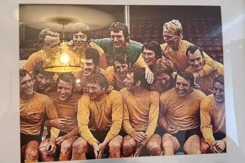 Ken Wagstaff A colour photograph showing a Hull City squad including Ken Wagstaff. The players are wearing amber shirts, black shorts and amber socks.