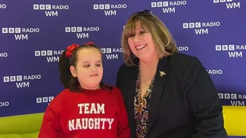 Cleo with her headteacher Joanna Garvey. They are sat on the BBC Radio WM sofa. 