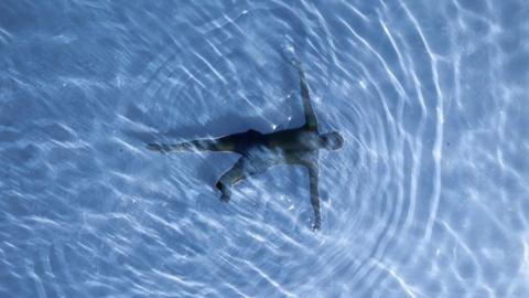 Bird's eye view of a swimmer underwater in a pool