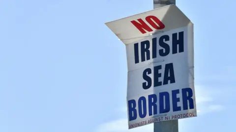 Reuters A poster reading "No Irish Sea border" is seen in the port of Larne.