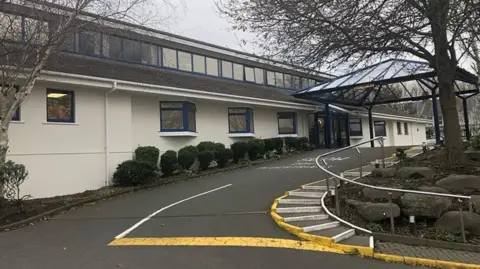 BBC The outside of the MSG, it is a two-storey white building.