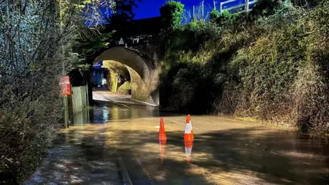 BBC A railway tunnel with flooded water and bollards underneath