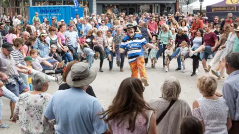Celidah in the square with Andrew James teaching crowds of adults and children how to dance