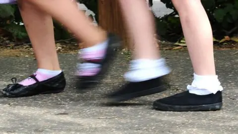 PA Media Two pairs of children's feet walking