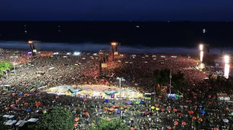 Getty Images Thousands of people on Copacabana beach at night, waiting for concert to begin