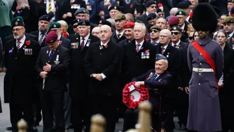 PA Media Veterans stand and mark the two minutes of silence