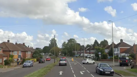 Cars travelling down Oadby Road with houses on either side