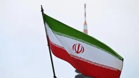 Iran's national flag flies atop the Consulate General of the Islamic Republic of Iran, with the TV tower in the background