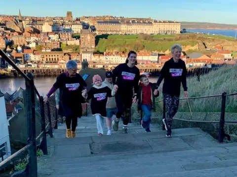 Bryony Jackson The trio along with Bryony's niece Isla and son Ted walking up the abbey steps 