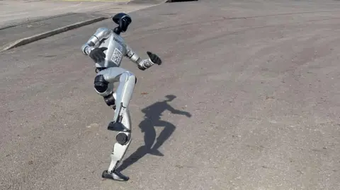 The robot is kicking one leg into the air
