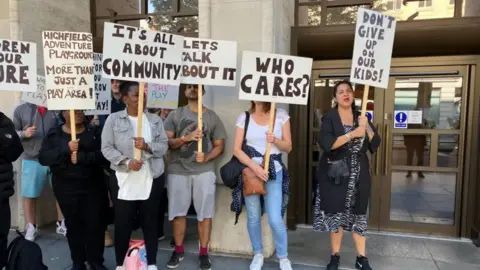 People holding placards as they campaign for support outside Leicester City Council's offices