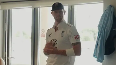Ben Stokes wearing his cricket uniform and a cap