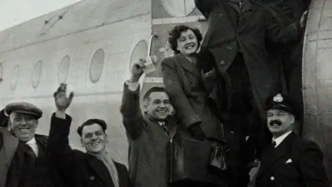 South Wales Police Heritage Centre Passengers including Dai and Kathleen Hawkins from Llanharan waving as they board the Avro Tudor aircraft on its way to Ireland.