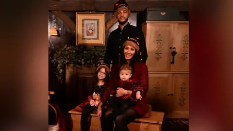 Contributor Picture A family of four sit in festive outfits