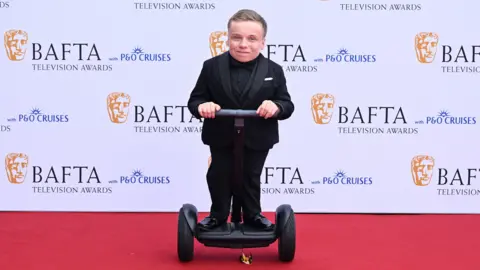 Getty Images Lenny Rush on a segway-style scooter on the red carpet