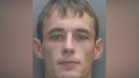 Merseyside Police A police mugshot of Dylan Westall, who has brown hair and stares into the camera with a serious expression.