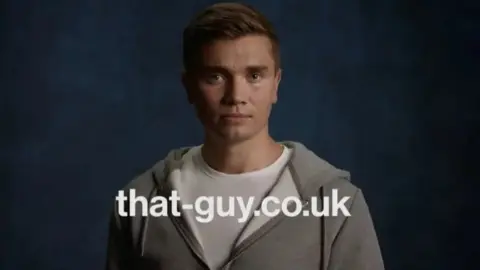 Police Scotland Grab from the advertising campaign video. It shows a young man in a white t-shirt and grey hoodie looking directly at the camera. There is a strapline that says that-guy dot co dot uk