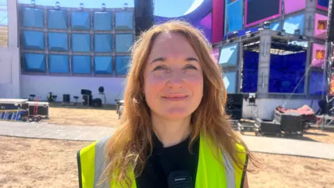 A woman smiling in high vis 