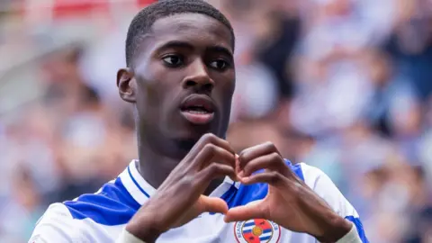 Kelvin Ehibhatiomhan poses with a heart shape as he celebrates a goal 