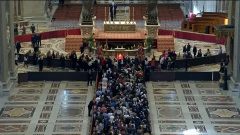 A crowd gathered inside St Peter's Basilica