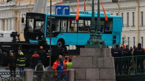 Bus being lifted out of the Moika River by a crane after crashing