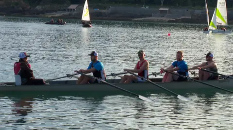 BBC Nicky Will leading as cox a team of four rowers in Havelet Bay