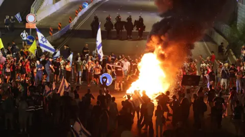 01 Eylül 2024'te Tel Aviv'in protestosu sırasında Ayalon'un ana otoyolunu engellerken Hamas'tan Gazze'den Gazze Işık Sourfires'a gözaltına alınan İsrail rehinelerinin ailelerini destekleyen APA'dan rezil.