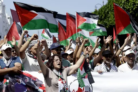 ABDEL MAJID BZIOUAT / AFP / GETTY IMAGES Moroccans chant slogans and wave the Palestinian flag during a march to express their solidarity with the Palestinians in the Gaza Strip, in Rabat.