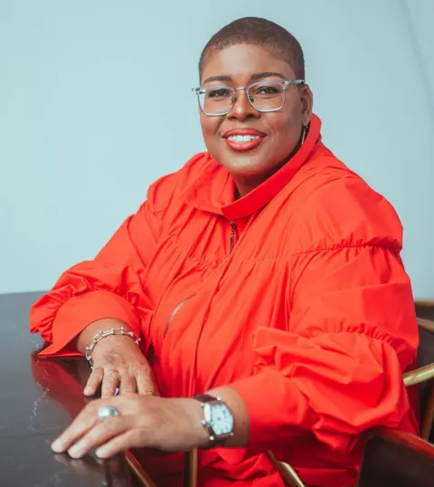 Leslie Ann St John Leslie Ann St John with closely cropped hair and a red blouse