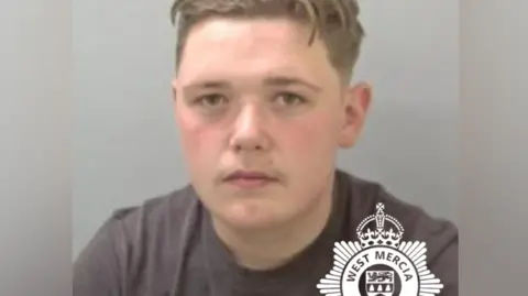 West Mercia Police A police mugshot of a 17 year old boy. He is wearing a black t-shirt and looking directly at the camera. 