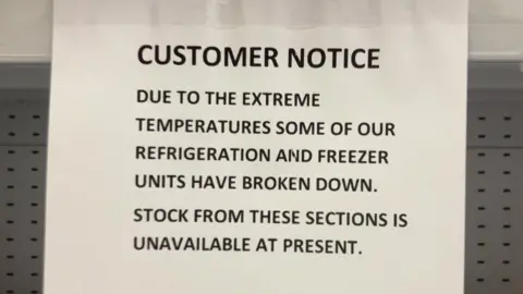 A notice in a store saying 'due to the extreme temperatures some of our refrigeration and freezer units have broken down. Stock from these sections is unavailable at present. We apologise for the inconvenience'.