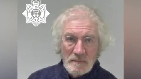 West Mercia Police A custody image of Timothy 'Paul' Barnes. He wears thin-rimmed glasses and a zip up jacket