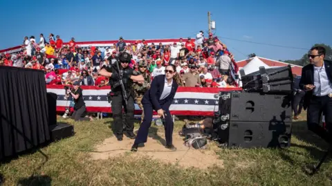 Getty Images Secret service draw their weapons after Trump is struck