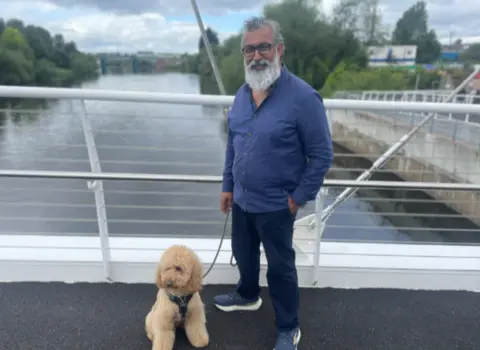 BBC/Harriet Pullen A fluffy dog on a bridge