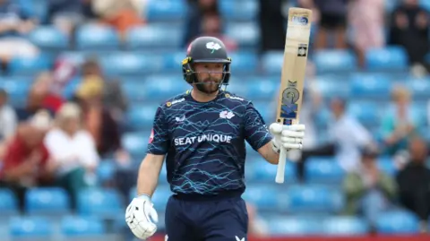 Yorkshire opener Adam Lyth raises his bat after reaching a T20 half-century