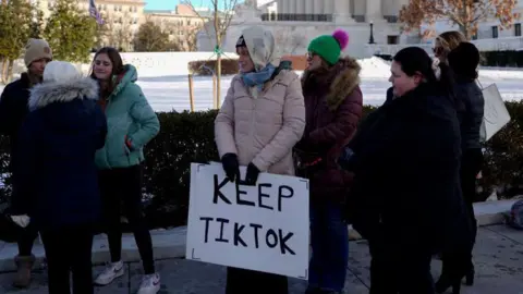 Getty Images A group of young people holding a sign reading 'Keep TikTok' stand in cold-weather clothes outside the Supreme Court in the US.