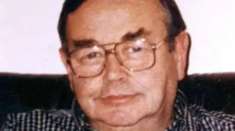 Family Handout Older man wearing large glasses and a checked shirt