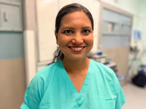 Dr Lucky Saraswat stands successful  a infirmary  corridor, wearing agleam  greenish  scrubs