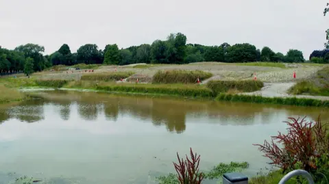 BBC Wide shot of a pond with traffic cones around the edges
