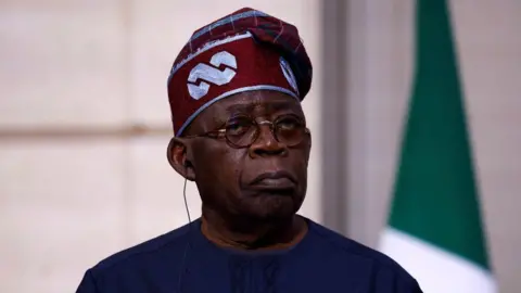 AFP via Getty Images Head and shoulders shot of Nigerin president Bola Tinubu.