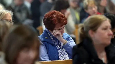 Getty Images A mourner wipes away a tear at a special mass at St Andrew's Cathedral in Glasgow after the announcement of the death of Pope Francis