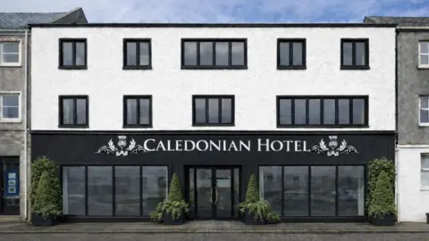 SSEN Transmission This image shows what the central part of the refurbished Caledonian Hotel could look like following refurbishment. There are large windows on the ground floor, some attractive plants outside and a large sign with the hotel's name. The building has a back and white frontage.